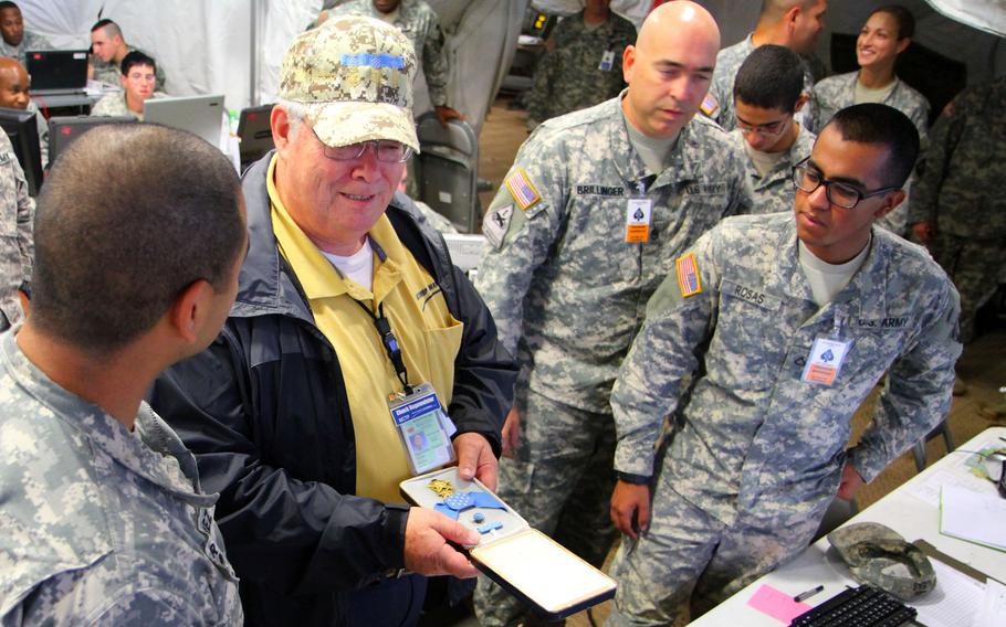 Medal of Honor recipient Charles Hagemeister shows his medal to soldiers working a night shift at Fort Campbell, Ky., Sept. 17, 2012.  Hagemeister, a former Army medic who earned the honor during the Vietnam War, died Wednesday, May 19, 2021. 