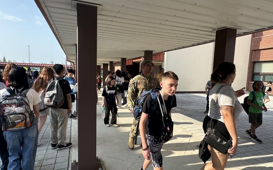 Students walk inside a school building.