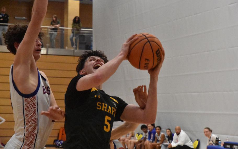 SHAPE’s Bela Clobes grimaces while putting up a shot Thursday, Feb. 15, 2024, at the DODEA European Division I Basketball Championships in Wiesbaden, Germany.