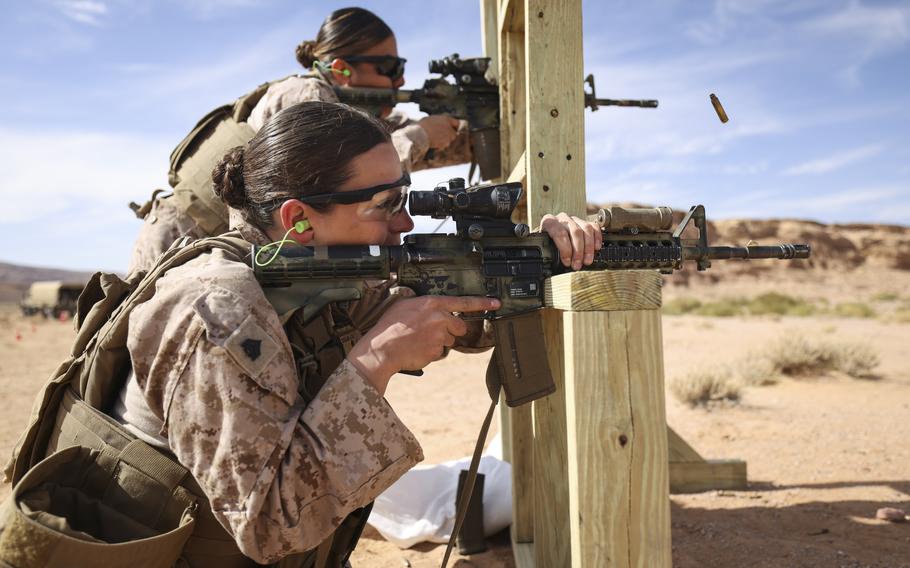 Two female troops firing weapons.