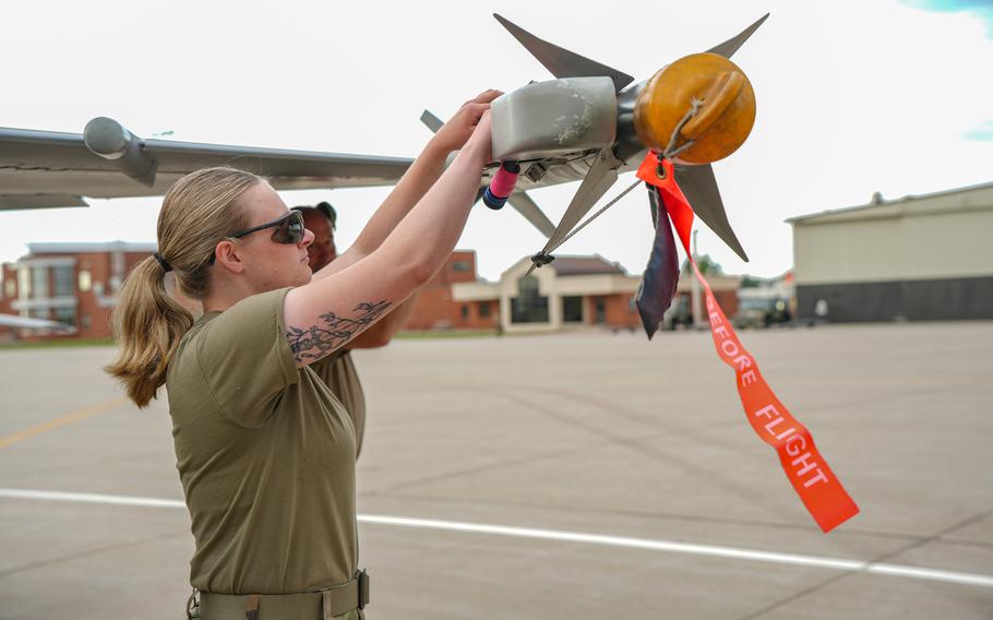 A woman loads munitions onto a plane.