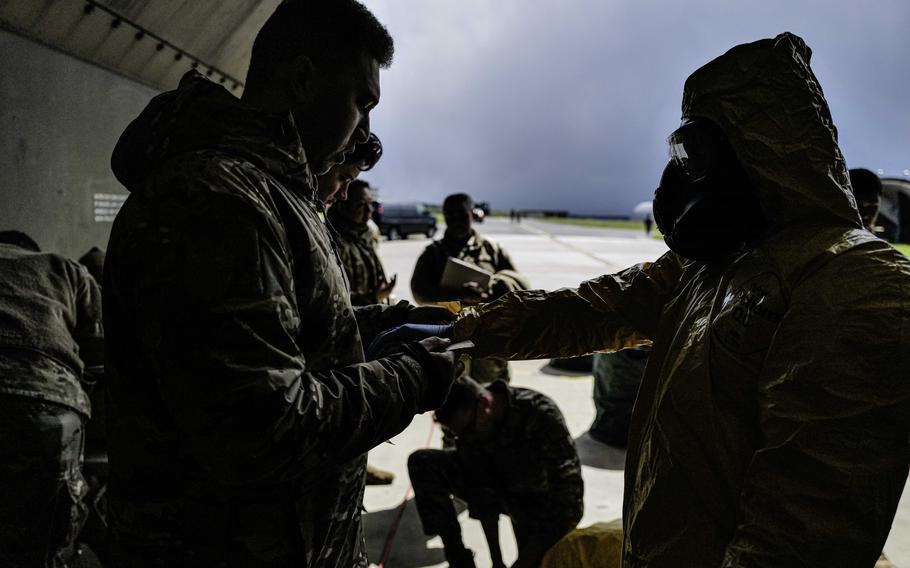 Staff Sgt. Christopher Richardson, left, secures sealing tape to a maintainer's protective suit during exercise Radiant Falcon on April 24, 2024, at Spangdahlem Air Base, Germany. The suits protect maintenance crew members from carrying particles with them after working on an aircraft that was exposed to radiation in flight.