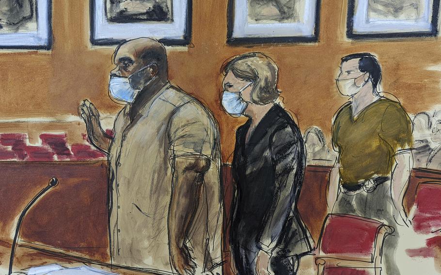 In this courtroom sketch, Frank James, left, the man accused in a mass shooting on a subway train in the Brooklyn borough of New York, is sworn-in during his arraignment in federal court, Friday, May 13, 2022, in New York. His defense attorney Mia Eisner-Grynberg is at center. James, 62, is facing charges of committing a terrorist attack or other violence against a mass transportation system and discharging a firearm during a violent crime. Both counts carry a maximum sentence of life in prison.