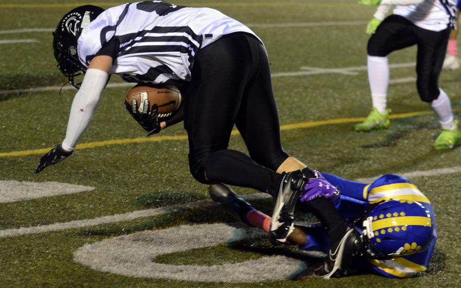 Zama receiver Caleb Schmiedel is tripped up by Yokota defender Braedan Raybon.