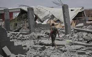 A soldier walking through rubble.