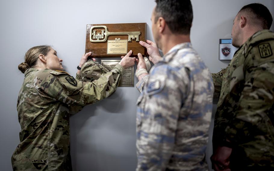 Army Col. Lisa Bartel, deputy commander of the 10th Army Air and Missile Defense Command, hangs a plaque presented at the ribbon cutting ceremony for the 11th Missile Defense Battery's new operational headquarters in Turkey on  May 18, 2023.