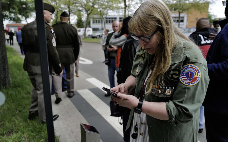 Edith Allison, a former intelligence analyst with the 2nd Military Intelligence Battalion, scans a QR code at the Husterhöh Kaserne audio guide unveiling, Wednesday, May 8, 2024, in Pirmasens, Germany. 
