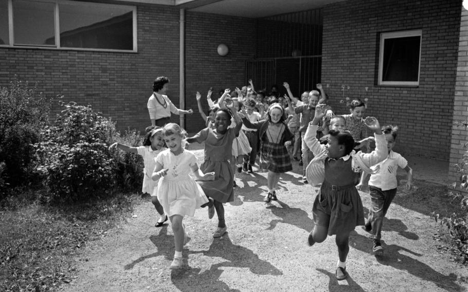 Kids running out of a school and cheering