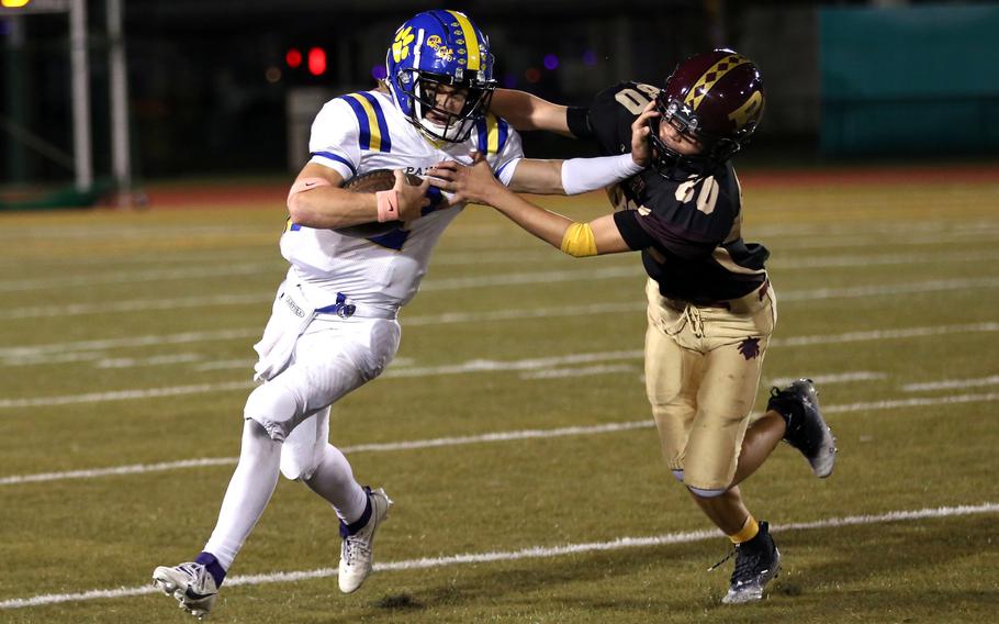 Yokota’s Josh Low, stiff-arming Perry defender Aiden Ealey, accounted for 205 yards total offense for the Panthers.