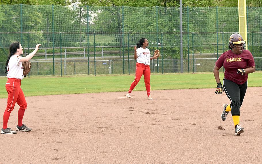 Vilseck's Scottlyn Smithson runs toward third base on a ground ball during the second game of Saturday's twin bill at Kaiserslautern High School in Kaiserslautern, Germany. From left are Raider shortstop Xin Ai Robinson and second baseman Selam Foery.