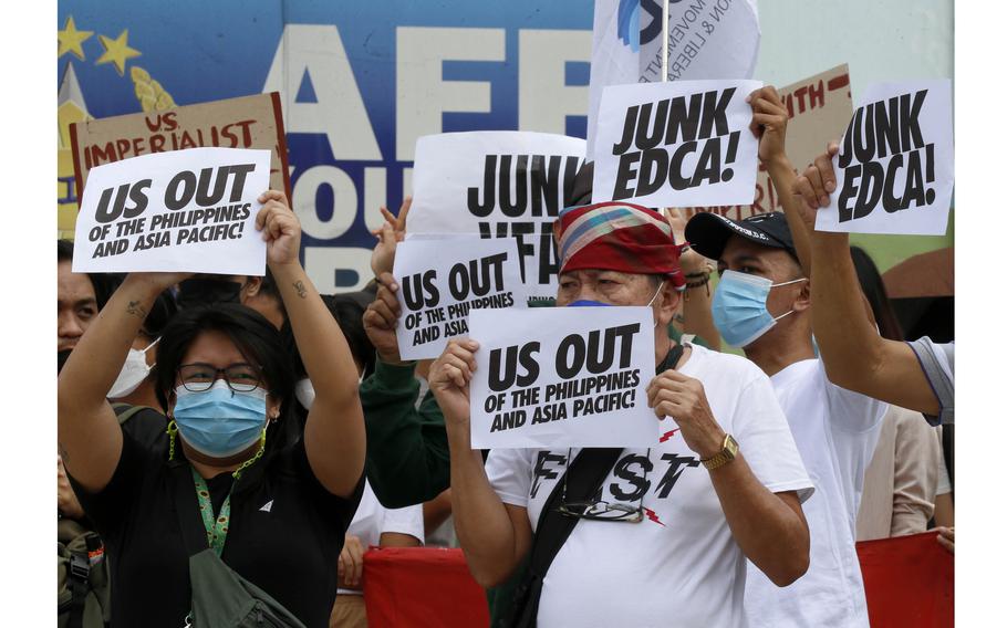 Protesters display placards and burn a mock US  flag to protest the visit of US Defense Secretary Lloyd Austin to the Philippines Thursday, Feb. 2, 2023, at Camp Aguinaldo in suburban Quezon city northeast of the capital Manila. 