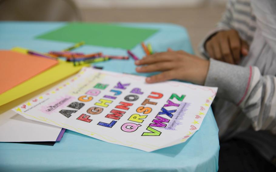 An Afghan child colors in the letters of the English alphabet during the opening of a new education center at Aman Omid Village on Holloman Air Force Base, N.M., Oct. 19, 2021. 