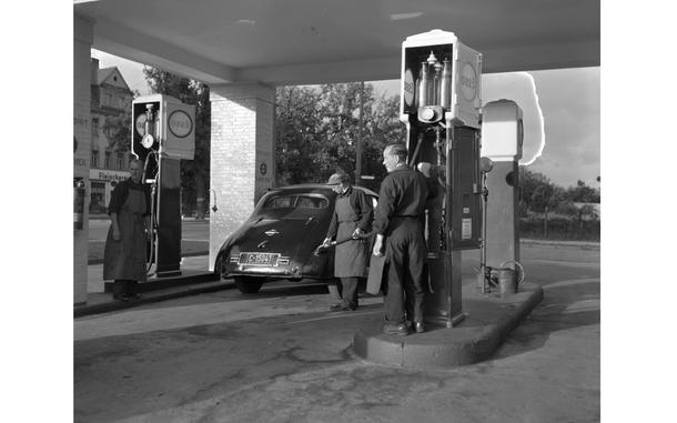 Hed: Gas rationing, 1948

Berlin, Germany, Sep. 21, 1948: An American gets his monthly ration of five gallons at the one service station in Berlin still serving privately-owned vehicles. 

The image is one of a series of 9 shot Sep. 21, 1948 by Stars and Stripes photographer Gerald Waller titled "Berlin Americans live normal life," to show how Americans were adapting living in Berlin during the Berlin Blockade which began June 24, 1948 when Soviet leader Josef Stalin imposed the blockade, cutting off all land and river transit between West Berlin and West Germany. In response, Western Allies initiated a massive airlift to get supplies into beleaguered Berlin. 

The original negative that this image was captured on suffers from a preservation issue called “silvering,” where the silver particles rise to the top of the gelatin layer of the film — you can see evidence of it in the form of the "lightning bolt" hitting the far right gas pump. 
During a preservation survey of Stripes’ photo collection in 2018, archives staff found that especially the 4x5 negatives from the late 1940s and early 1950s were suffering the most from this preservation issue. As the “silvering” will eventually cause the image captured on the negative to fade, the affected negatives were pulled and prioritized for scanning.

Read Waller's article and see additional photos here.

https://www.stripes.com/history/2025-05-09/stars-stripes-archive-yanks-in-berlin-normal-lives-1948-17701040.html

Looking for Stars and Stripes’ historic coverage? Subscribe to Stars and Stripes’ historic newspaper archive! We have digitized our 1948-1999 European and Pacific editions, as well as several of our WWII editions and made them available online through https://starsandstripes.newspaperarchive.com/

META TAGS: post-war Germany; Berlin; Berlin Blockade; Cold War; Berlin airlift; dependents; military life; military family; West Berlin; American sector