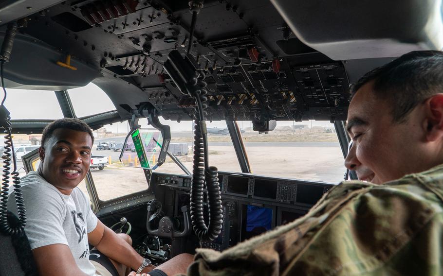 Elijah Higgins sits in an aircraft and speaks to an airman