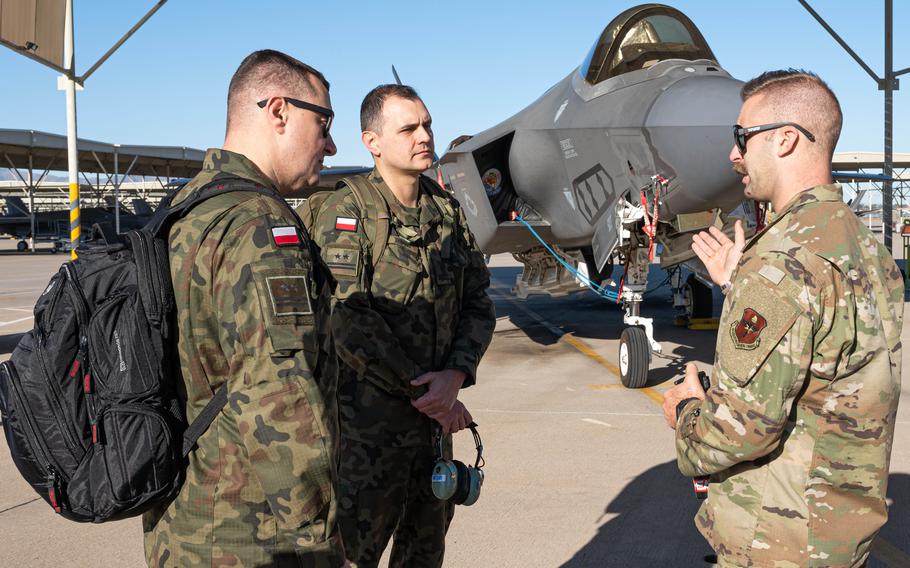 U.S. Air Force Tech. Sgt. Raymond Lemmert, right, briefs Polish air force Lt. Col. Pawal Muzyczuk, left, and Lt. Col. Rafal Zawadka on F-35 maintenance operations in 2022 at Luke Air Force Base, Ariz. 