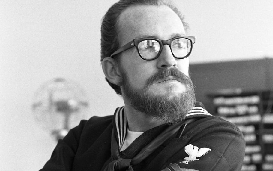 Sporting a beard, Petty Officer 2nd Class Michael Crump, a Navy journalist, sits in his office in Naples, Italy, in 1971.