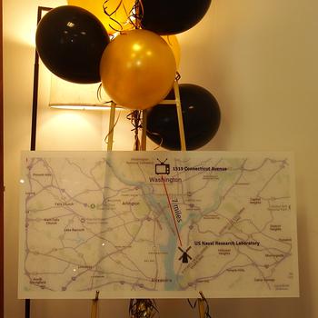 A poster of a map below some black and yellow balloons.