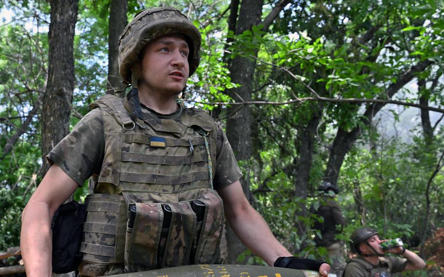 A Ukrainian artilleryman carries a 155 mm shell to fire a M777 howitzer toward Russian positions near Avdiivka in the Donetsk region on June 23, 2023, amid the Russian invasion of Ukraine. 