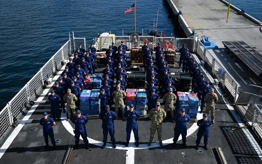 Crew members and shipments on the deck of a ship.