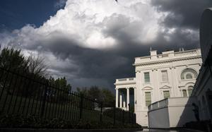 A side view of the White House, with clouds overhead.