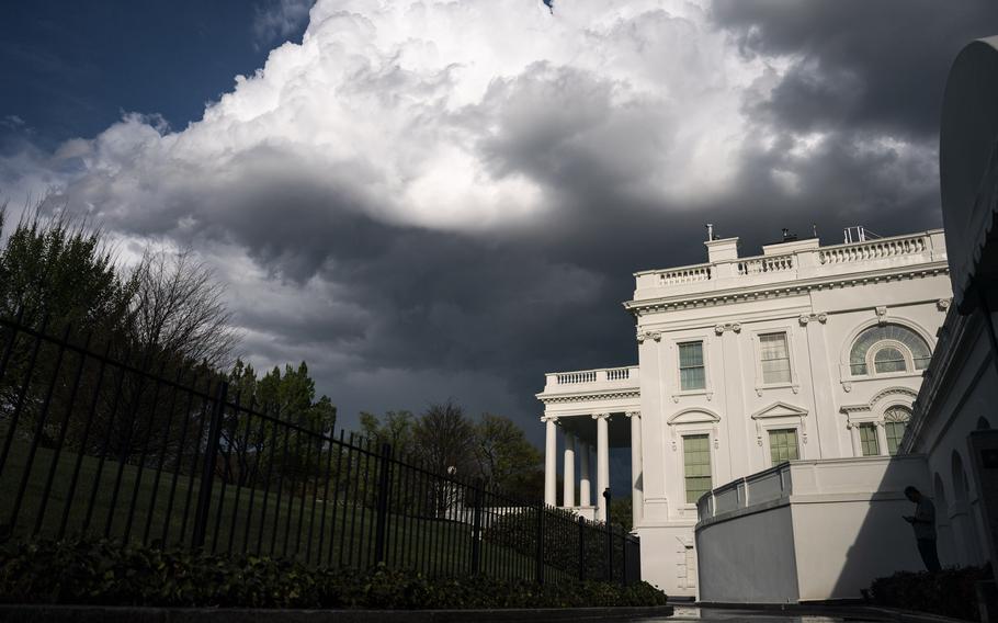A side view of the White House, with clouds overhead.