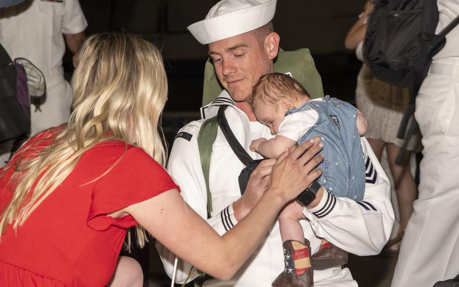 A sailor assigned to the aircraft carrier USS Nimitz reunites with his family during the ship’s homecoming.