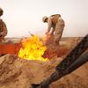 U.S. Marine Lance Cpl. Nathanial Fink (left), a light-armored vehicle driver with Alpha Company, 1st Light Armored Reconnaissance Battalion, and 19-year-old native of Neenah, Wis., and Lance Cpl. Garrett Camacho, a food service specialist with Headquarter and Service Company, and 19-year-old native of Fredericksburg, Va., dispose of trash in a burn pit here, March 3. During a convoy to Patrol Base Sre Kala, an unexpected sandstorm halted the Alpha Company Marines and sailors for nearly 36 hours.