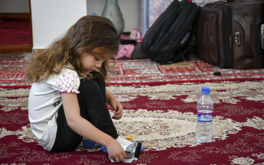 Zainab Asadi, 5, snacks on chocolate May 31, 2021, in the home where she and her family hid for six months. Her father, Mohammed Naiem Asadi, said he moved his family into hiding after his superiors in the Afghan air force became angry that he received permission to leave the country for America. 