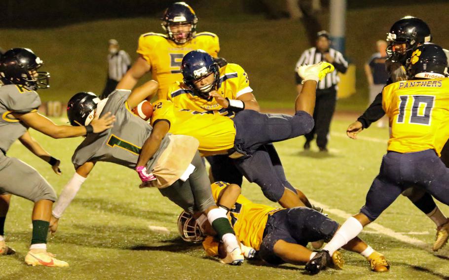 Guam High's Terrell Rosario and DeShawn Baird bring down John F. Kennedy's Trey Fields.