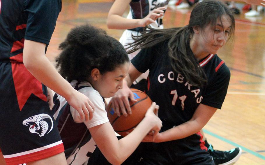 Matthew C. Perry’s Nyla Matos and E.J. King’s Maliwan Schinker tussle for the ball during Saturday’s DODEA-Japan girls basketball game. The Cobras won 51-18.