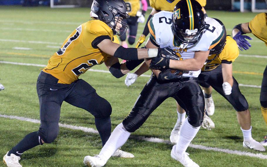 Robert D. Edgren running back Aiden Larry fights to keep the ball from American School In Japan's Noa Grasse.