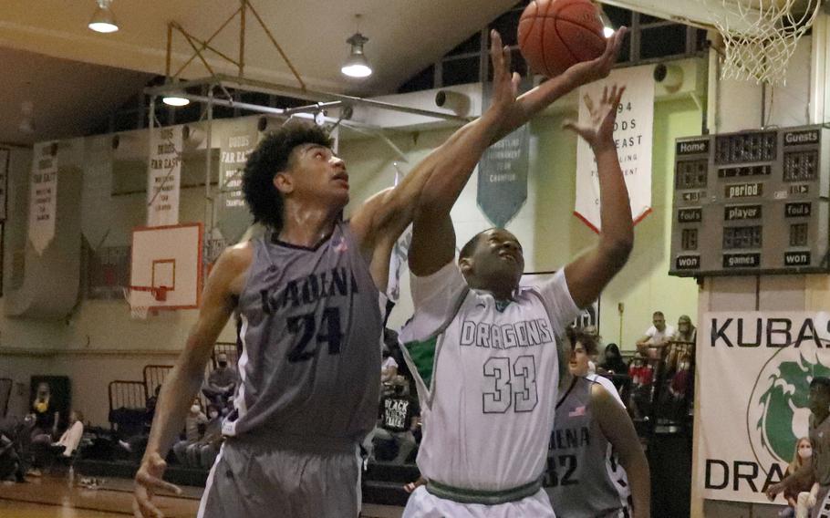 Kadena's Jeremiah Lewis and Kubasaki's Terrence Reese sky for a rebound during Thursday's Okinawa boys basketball game. The Dragons rallied to win 47-37.