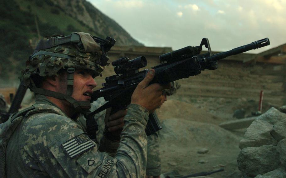A U.S. Army Soldier with 1st Battalion, 32nd Infantry Regiment, 10th Mountain Division, fires at anti-Afghanistan forces in the hills surrounding the remote village of Barge Matal during Operation Mountain Fire, in Afghanistan's Nuristan province, July 2009.
