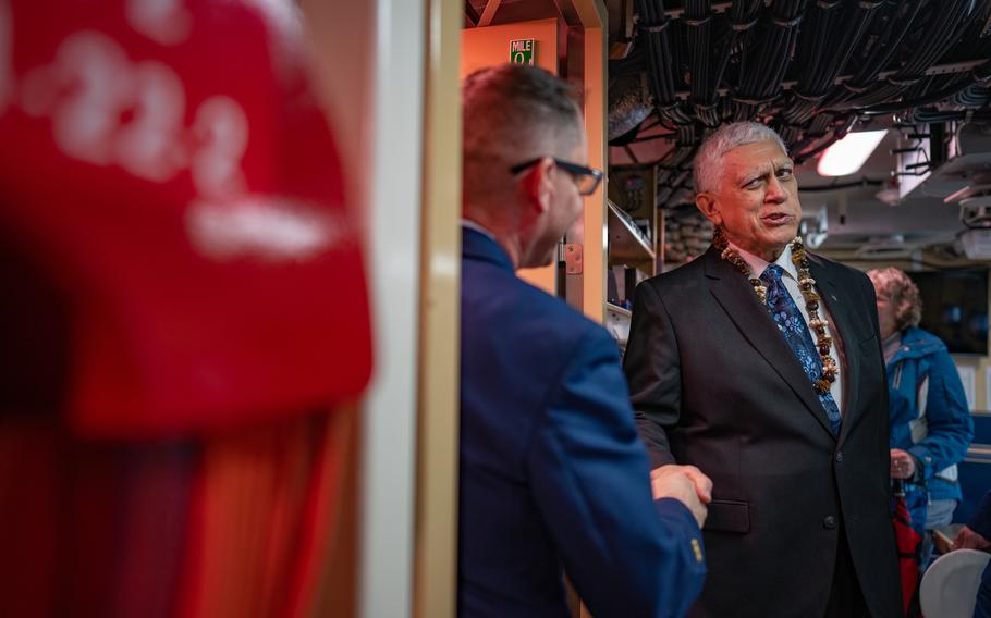 Robert Bell shakes hands with a crew member of the newly commissioned Coast Guard Cutter Melvin Bell at the Coast Guard Academy in New London, Conn., March 28, 2024. 