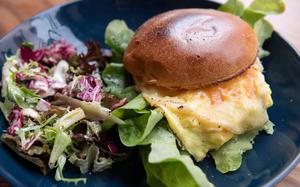 Cafe Selen’s breakfast burger includes a warm scrambled egg patty, leafy greens, pink pickled onions and a spicy vegan mayo, inside a brioche bun.
