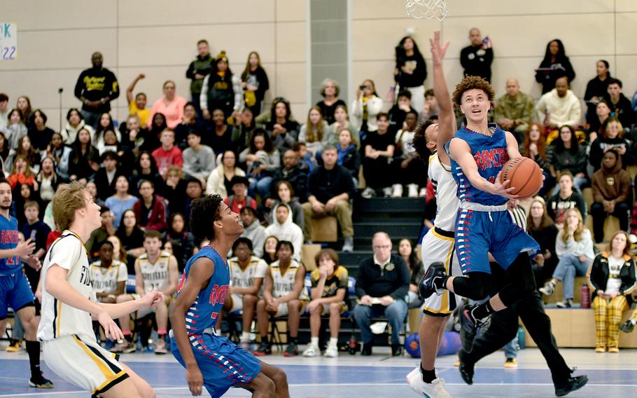 Ramstein's Timar Dix goes up for a layup as Stuttgart's Trenton Jackson defends during pool play on Wednesday at Ramstein High School on Ramstein Air Base, Germany.