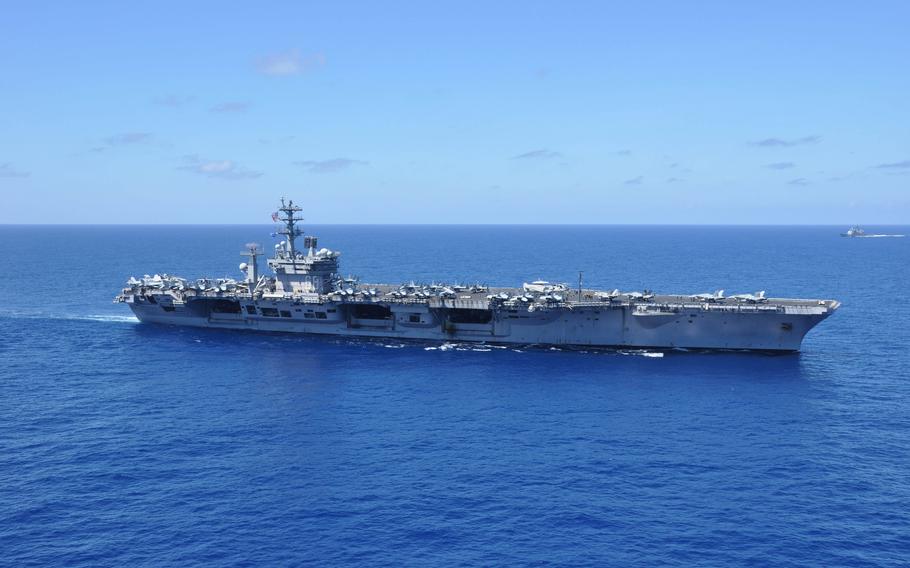 A sideview of an aircraft carrier at sea.