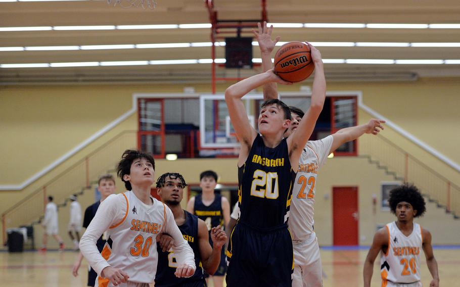 Spangdahlem’s Casey Supinger attempts to block a shot by Ansbach’s Lucas Rudy, as their teammates watch the action in a D-III game on opening day of the DODEA-Europe basketball finals in Baumholder, Germany, Feb. 15, 2023. 
