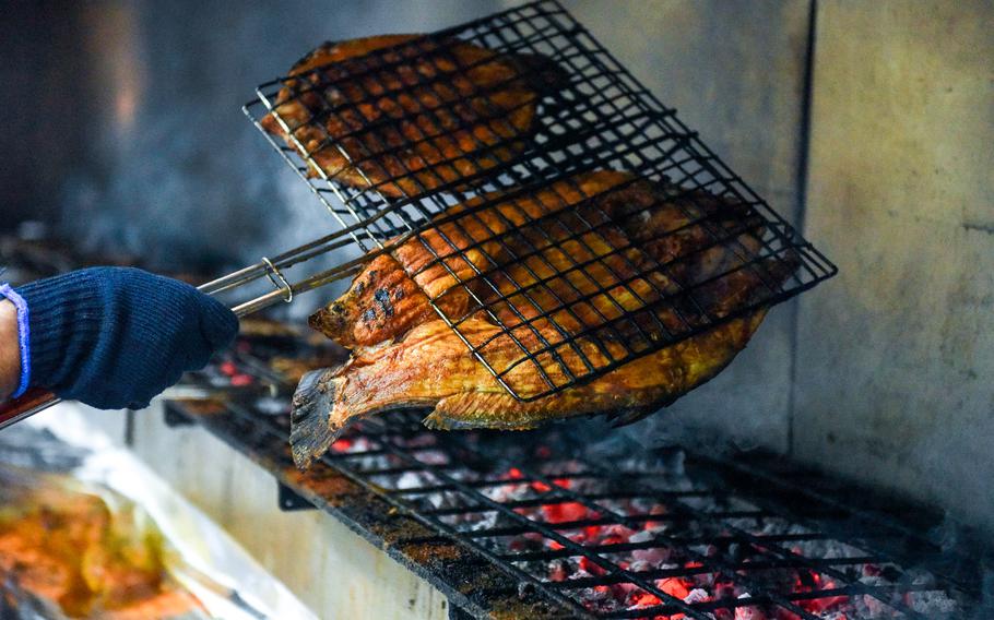 Fish are grilled over charcoal. 