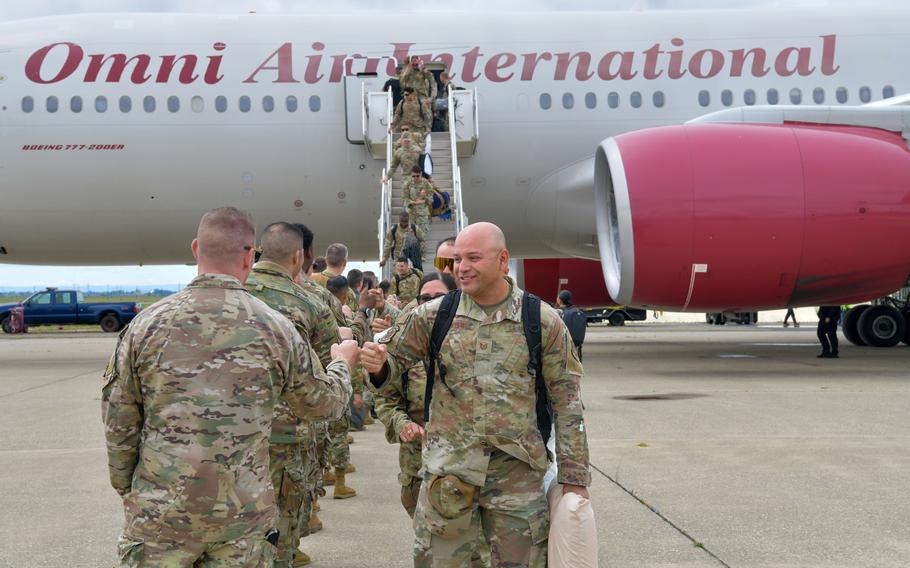 Airmen walk off an airplane