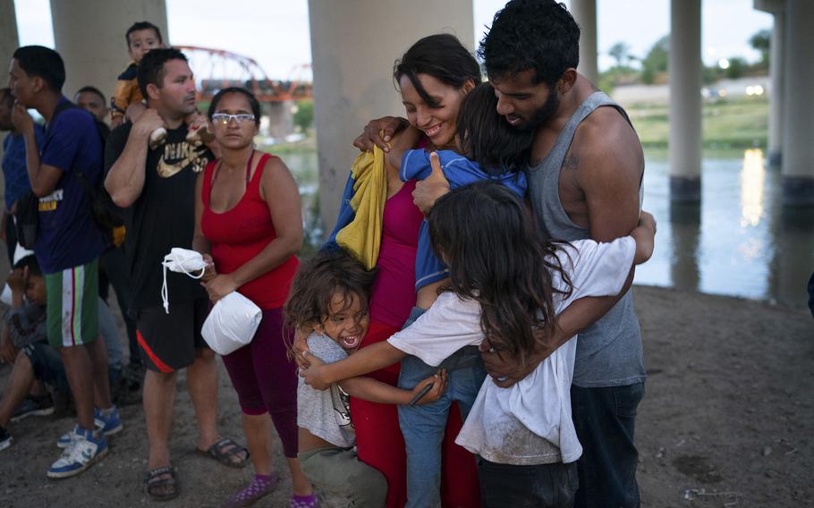 Brismar Romero, center, of Venezuela, and her husband, Jesus Uranga have a celebratory family hug in Eagle Pass shortly after crossing the Rio Grande into the United States on Aug. 12, 2022.