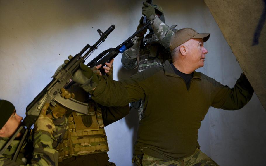 Patrick Creed, a retired U.S. Army major, guides members of the Ukrainian Territorial Defense Forces as they clear a stairwell at a training site outside Kyiv, Ukraine, on Nov. 2, 2022. Creed is a member of The Mozart Group, a private security company of mostly military veterans who traveled to Ukraine to train that country’s troops.