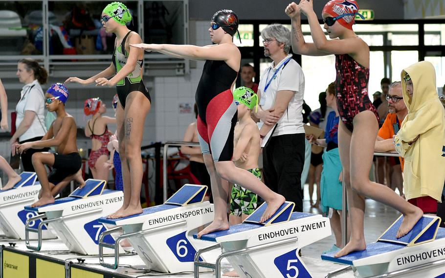 From left, Micaiah Gilchrist of Kaiserslautern, Alana Epperly of Naples, Evelyn Pfeiffer of Stuttgart and Sienna Spencer of Rota gesture to their teammates in the pool during the mixed Under-10 200-meter freestyle relay on Sunday during the European Forces Swim League Short Distance Championships at the Pieter van den Hoogenband Zwemstadion at the Zwemcentrum de Tongelreep in Eindhoven, Netherlands.