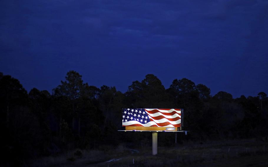 A billboard shows a depiction of an American flag alongside a highway at dusk in North Port, Florida, Feb. 21, 2016. 