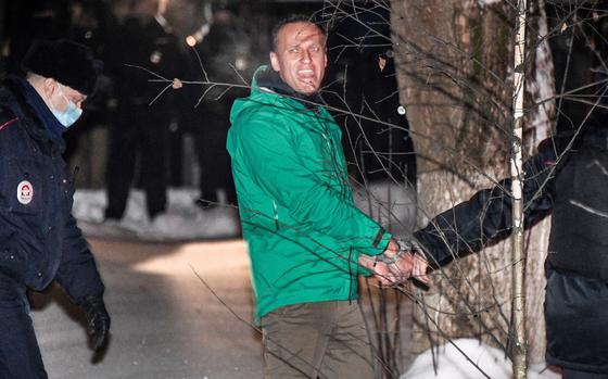 Alexei Navalny is escorted out of a police station on Jan. 18, 2021, in Khimki, Russia, outside Moscow.