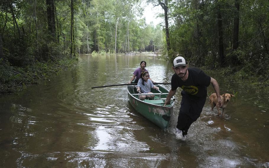 Alvaro Trevino pulls a canoe with Jennifer Tellez and Ailyn, 8, after they checked on their home on May 5, 2024, in Spendora, Texas. 