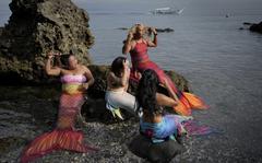 Queen Pangke Tabora, right, and her students prepare for a mermaiding class at the Ocean Camp in Mabini, Batangas province, Philippines on Sunday, May 22, 2022.