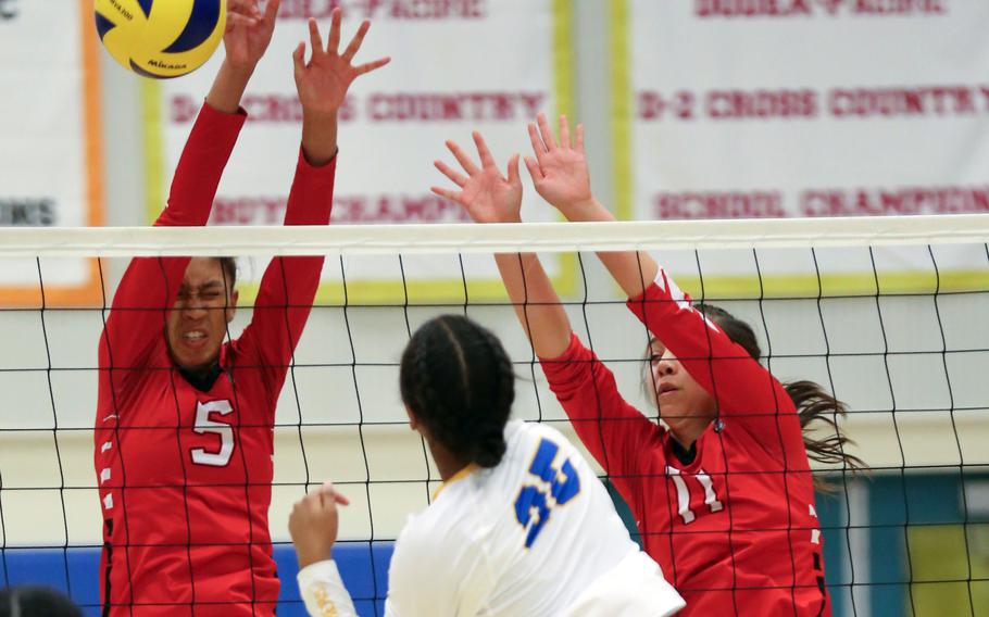 Yokota's Trinity Stegall (25) spikes against E.J. King's Mila Nishimura-Reed and Maliwan Schinker. The three were named to the Far East Division II girls volleyball tournament's All-Tournament team.