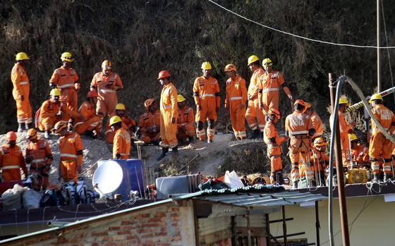 Rescuers rest at the site of an under-construction road tunnel that collapsed in Silkyara in the northern Indian state of Uttarakhand, on Nov. 24, 2023.