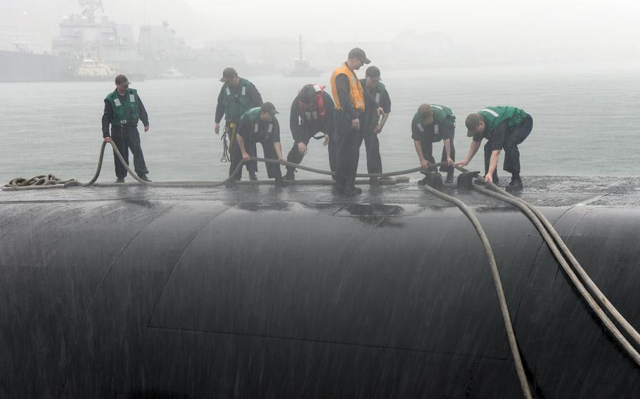 Sailors heave a line to bring the Ohio-class ballistic missile submarine USS Kentucky into port in Busan, South Korea, Tuesday, July 18, 2023.